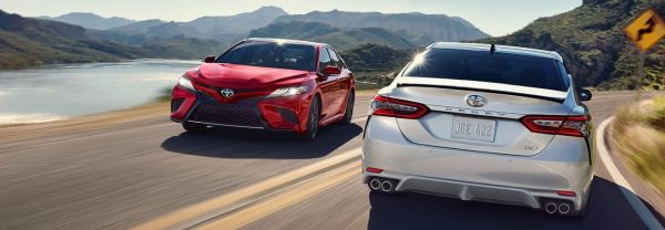 Two 2019 Toyota Camry models driving past each other on the road